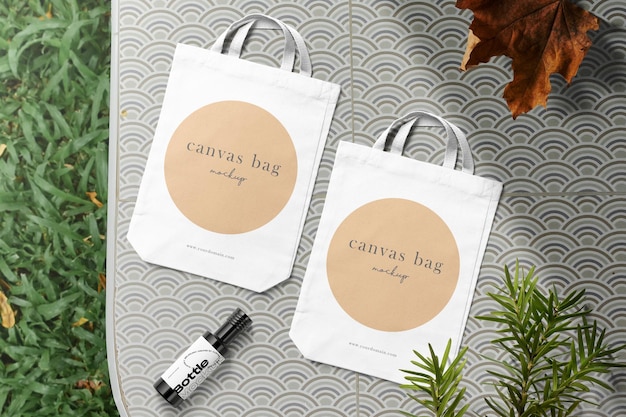 PSD | Clean minimal canvas bag mockup on table background with bottle conifer and leaf