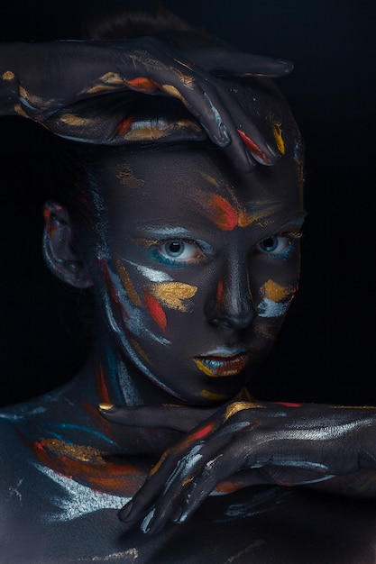 Photo | Young woman who is posing covered with  black paint